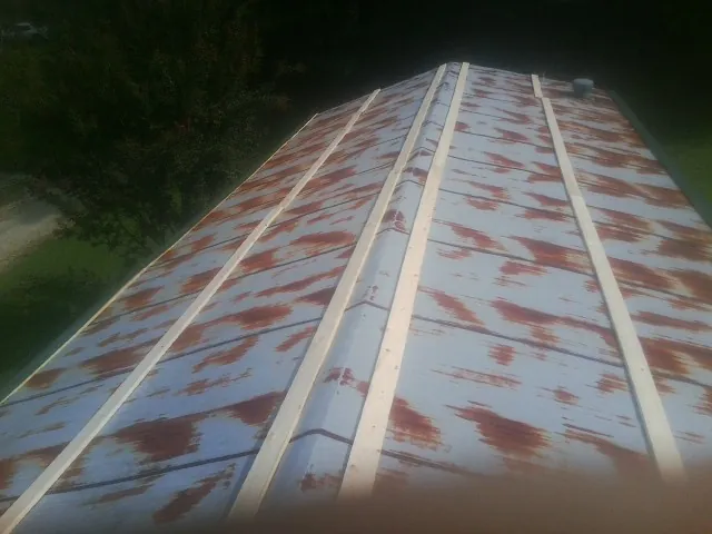 Rusted metal roof panels with new wood purlins before replacement — Storm Damage Roof Repair in Palco by Roofing Brothers